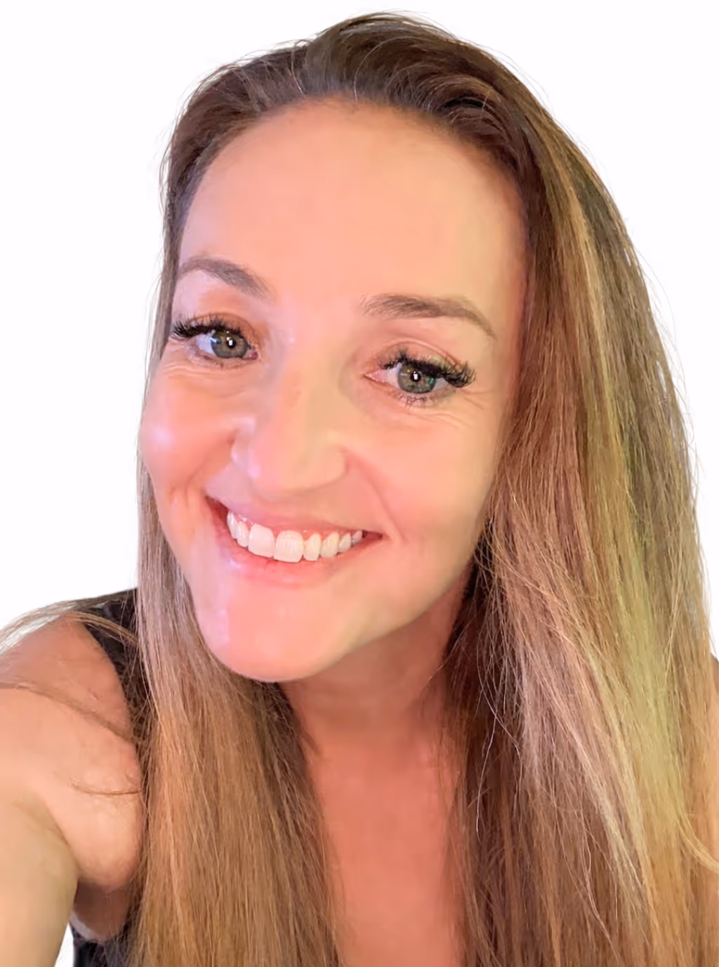 Close-up of a smiling woman with long light brown hair and green eyes against a white background.